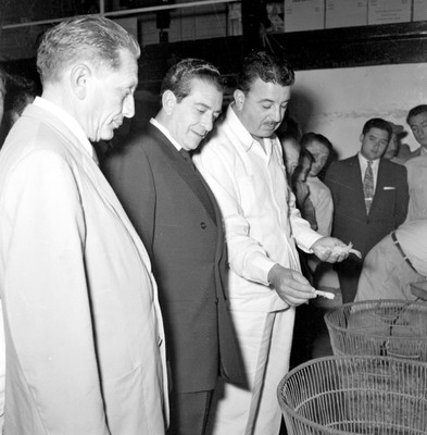 Adolfo López Mateos con políticos mientras un hombre muestra mariscos en la Congeladora Madero de Cd. del Carmen