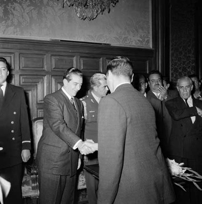 Adolfo López Mateos saludando a miembro de la Comisión de la Caravana de la Gratitud de San Luis Potosí en un salón de palacio nacional