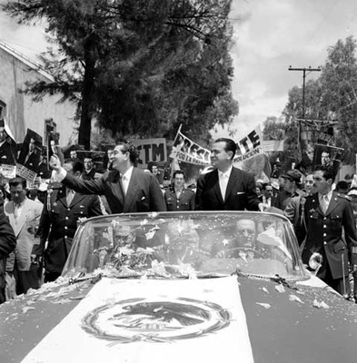 Adolfo López Mateos y Francisco Martínez de la Vega recorriendo las calles de San Luis en un vehículo