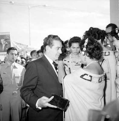 Adolfo López Mateos le colocan un distintivo en la solapa de su traje, durante un recorrido por Chetumal