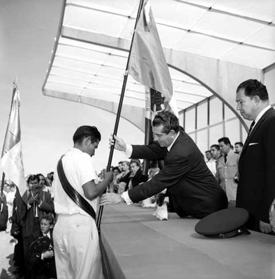 Adolfo López Mateos entrega la Enseña Nacional, a un campesino en una ceremonia