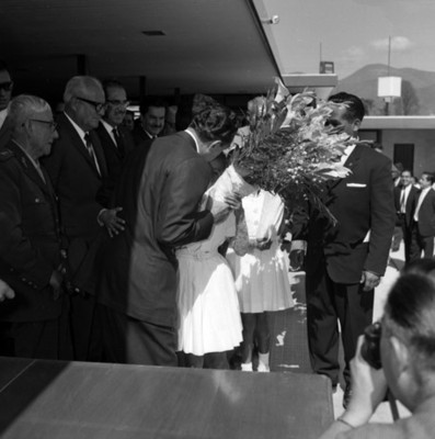 Adolfo López Mateos con su comitiva recibe flores de una niña, durante la inauguración de la escuela Josefa Ortiz de Dominguez