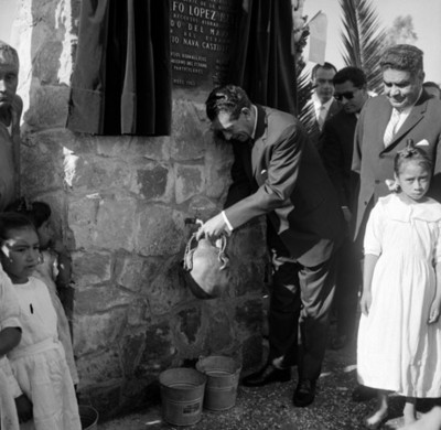 Adolfo López Mateos llenanddo un cántaro de agua durante la inauguración de Agua Potable Acatlán