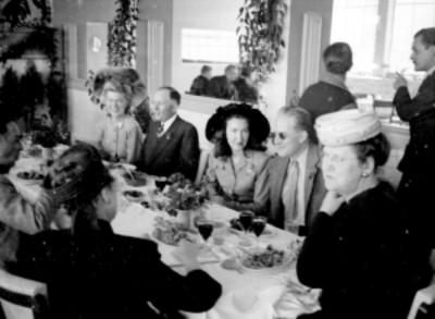 Actrices y empresarios cinematográficos conversando en un banquete