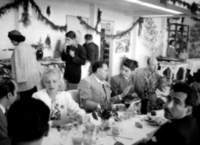 Actores y actrices dialogando durante un banquete