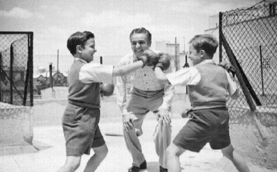 Arturo de Córdova observa como dos niños, practican box