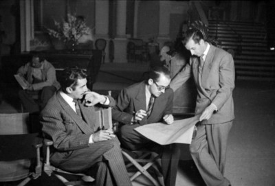 Director y productores de cine revisando el guión en la filmación de una película
