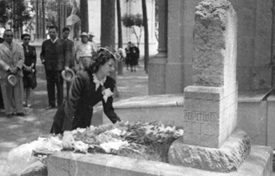 Esther Fernández hincada colocando ramo de flores en la tumba de Federico Gamboa