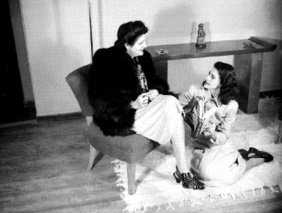 Carmen Montejo platicando con una mujer, vestida de manera elegante