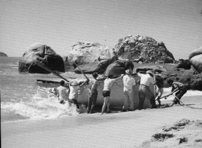 Forilleros empujando una embarcación hacia el agua