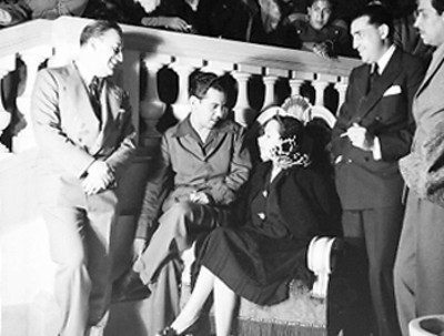 Dolores del Río conversando con Mario Moreno y otros actores durante la premier de la película El Gran Hotel