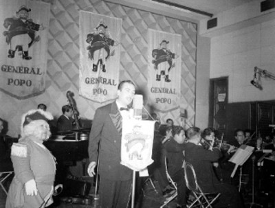 Cantante femenina en escena con orquesta durante programa de radio de la General Popo