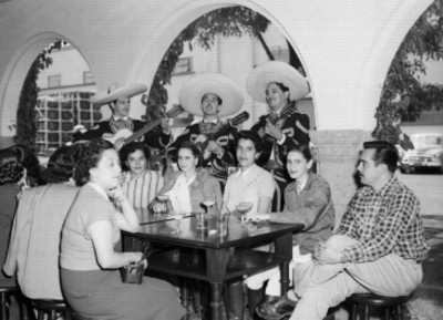 Gente escuchando un mariachi en el Club Azteca durante un concurso hípico