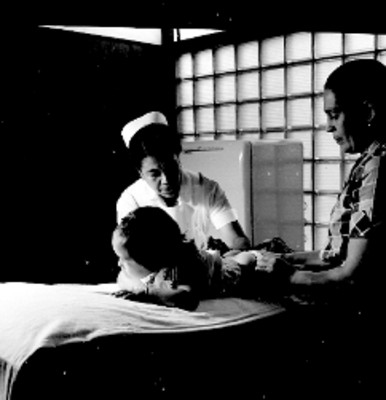 Enfermera vacunando a una niña dentro de un consultorio
