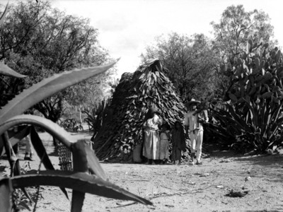 Familia en el exterior de una casa de pencas de maguey, retrato de grupo