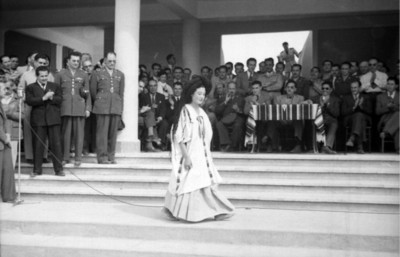 Mujer muestra traje regional de Hidalgo al presidente Miguel Alemán Valdés y su comitiva