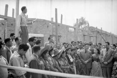Hombre dirige un discurso a Miguel Alemán Valdés durante gira