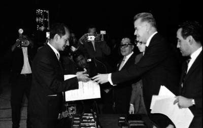 Javier Barros Sierra entregando el reconocimiento a un académico en una ceremonia en un auditorio