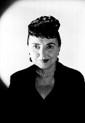 Margo de Taxco de frente sonríe, usa vestido oscuro y collar de perlas, retrato