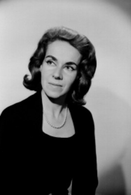 Margot Wagner en tres cuartos de perfil con vestido oscuro y collar, retrato