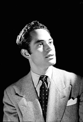 Julio Toledo, actor, rostro levantado, viste de traje y corbata, retrato