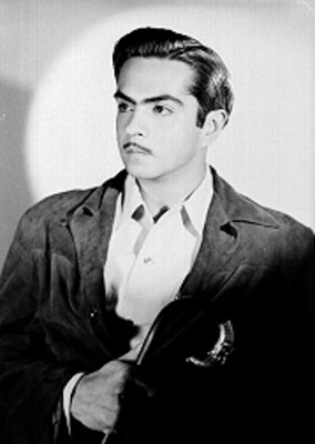 Antonio López Mancera, escenografo, viste una gabardina con baston en mano, retrato de perfil