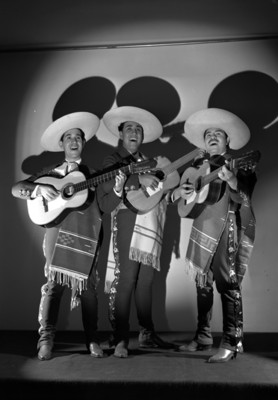 Trio Janitzio, de frente simulan cantar, con atuendos folkloricos y guitarras, retrato