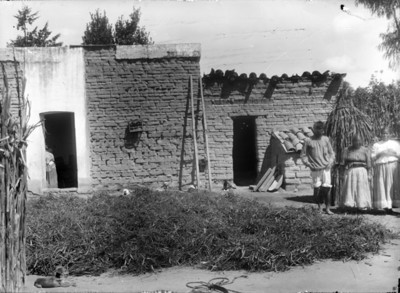 Mujeres y hombre mazahua frente a su vivienda