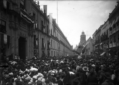 Multitud de personas rodean el carro alegórico de la pila bautismal del Hidalgo frente al Museo Nacional