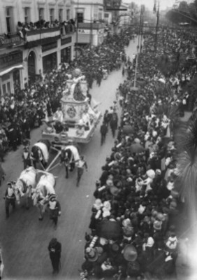 Personas observan desfilar el Carro alegórico de las Ciencias