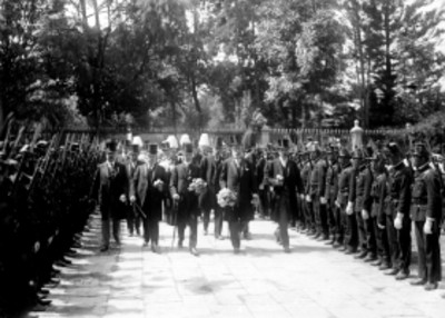 Hombres caminan con ofrenda a las tumbas de los Héroes de Independencia