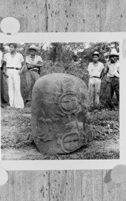 Hombres junto a una escultura de bajo relieve, reprografía