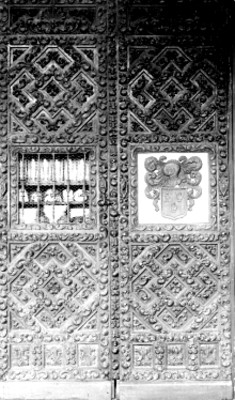 Puerta tallada con escudo heráldico