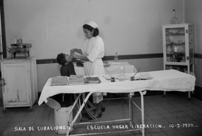 Enfermera aplica curación a huérfano de la Escula Hogar Liberación