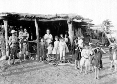 Mujeres y niños indígenas fuera de una vivienda, retrato de grupo
