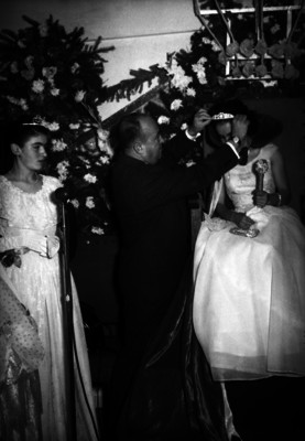 César Cervantes coronando a una reina durante un evento