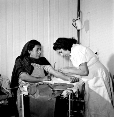 Enfermera vacuna a mujer en el brazo