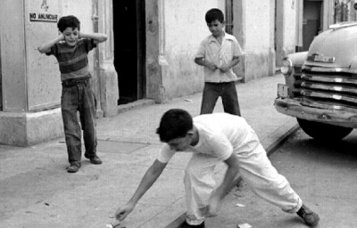 Niños encienden cohetes en una acera
