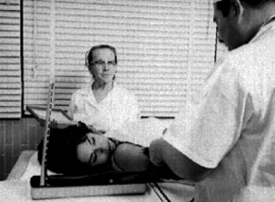 Médico revisa a mujer enferma en un consultorio