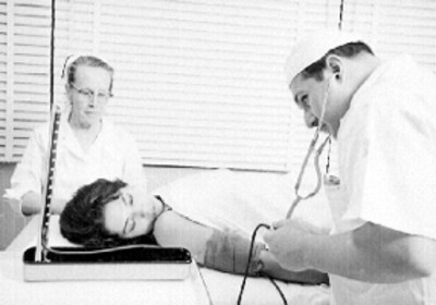 Médico examina a mujer en un consultorio
