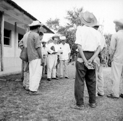 Ingeniero da instrucciones a cañeros en un campamento