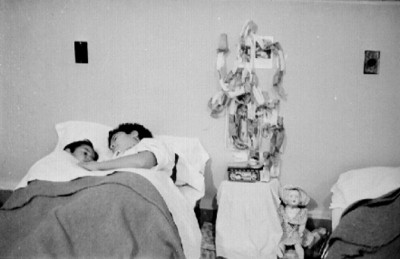 Niño con su mamá acostados en la cama de un albergue