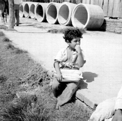 Niño con elotes sentados sobre una calle