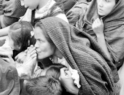 Mujer besa los pies de hombre durante representación de la Pasión de Cristo