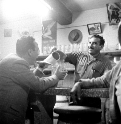 Cantinero sirve pulque a bebedor