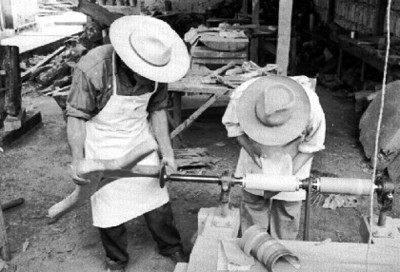 Hombres pulen artesania con máquina industrial
