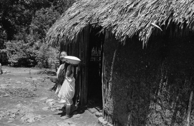 Mujer maya cerca de una casa de bajarenque