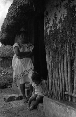 Mujer y niño cerca de una casa de bajarenque