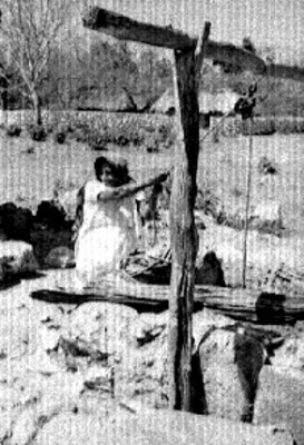 Mujer maya saca agua de un pozo