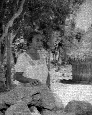 Mujer maya junto a unas piedras